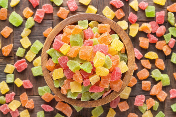 candied fruit, colorful cubes in wooden bowl, top view. candied fruit, colorful cubes in bowl on wooden table background. candied fruit stock pictures, royalty-free photos & images