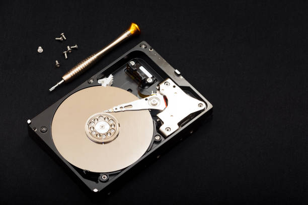 istock Internal parts of the hard drive. HDD. Computer memory. Modern technologies. Computer repair. Black background. Free space for text. Recover lost data. Screwdriver and bolts near the hard drive. 1225190820