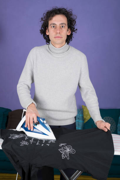istock a young man ironing in the house 1225191940