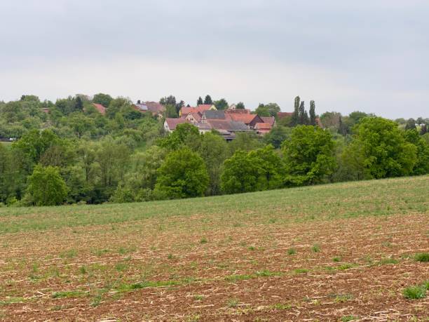 istock Agricultural field and small village in springtime 1225192012