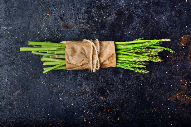 Freshly caught light asparagus Freshly caught light asparagus on a rustic kitchen table asparagus photos stock pictures, royalty-free photos & images