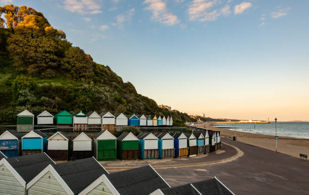 cabanas de praia na costa em bournemouth ao pôr do sol - bournemouth - fotografias e filmes do acervo
