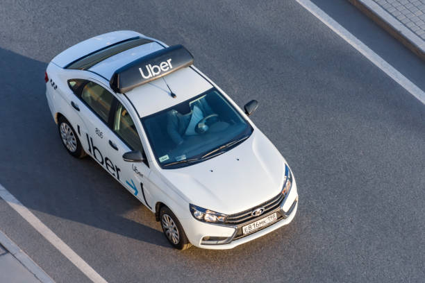 白い乗客の白い車uber taxiは、高速道路の空中写真に乗ります。ロシア、サンクトペテルブルク。2020年4月14日。 - 運賃 写真 ストックフォトと画像