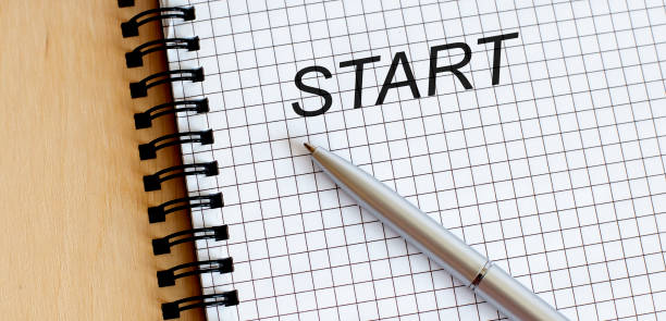 istock top view of a open notebook with pen and text Start 1225201066