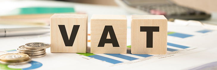 Vat on wooden cubes over blur background with copy spcae, financial concept background