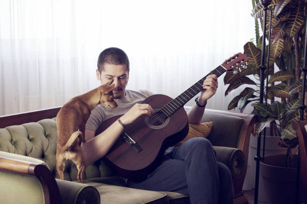 istock Man is playing guitar with his dog. 1225204455