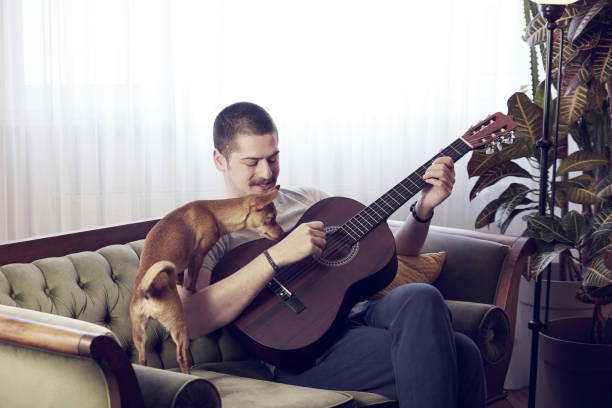 istock Man is playing guitar with his dog. 1225204711