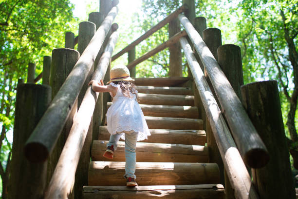 menina subindo as escadas no parque - child mixed race person little girls human gender - fotografias e filmes do acervo