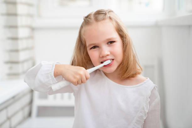 istock funny girl cleans teeth electric toothbrush 1225209907