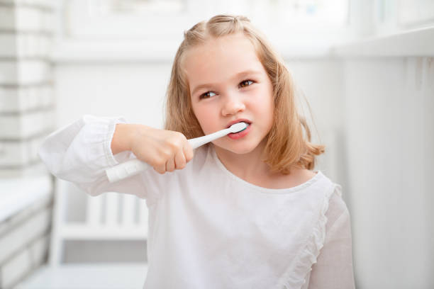 istock funny girl cleans teeth electric toothbrush 1225209932