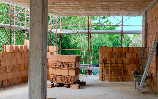 istock Stack of brick bricks, shovel, broom and other work tools of a bricklayer on a construction site 1225212341