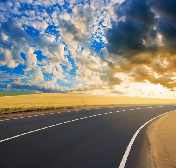 istock asphalt road turn among a fields at the sunset 1225216887