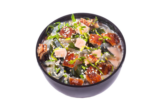 istock in a black plate or bowl, tom yam kimchi soup with chicken or eel fish, on an isolated white background 1225219463