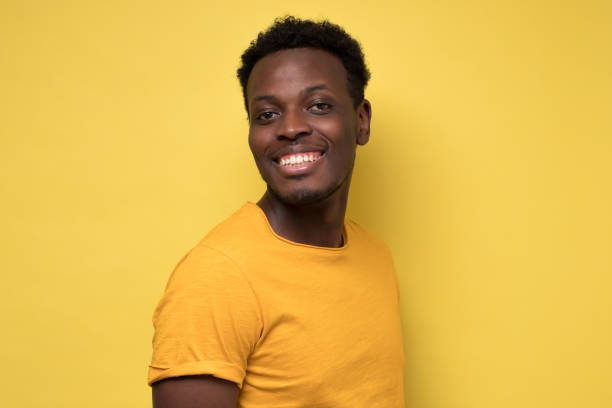 istock young african man posing in front of camera on yellow background. 1225222137