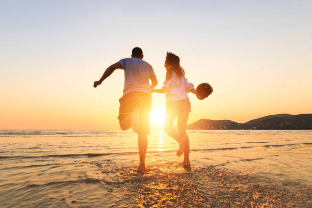 istock couple running and hand hold on the beach between sunset. 1225222399