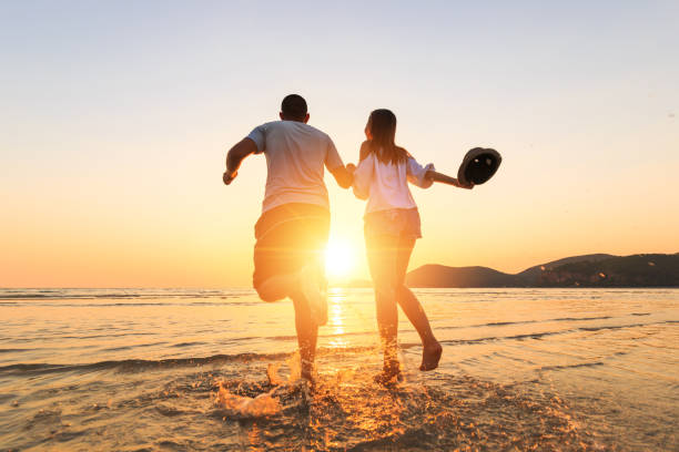 istock couple running and hand hold on the beach between sunset. 1225222408