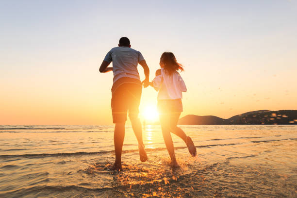 istock couple running and hand hold on the beach between sunset. 1225222409