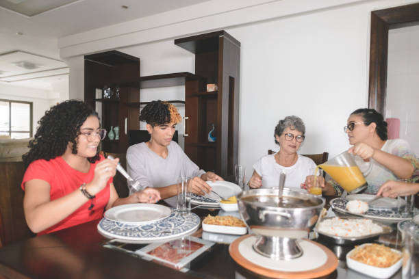 istock Family having lunch at dining table served with feijoada, typical brazilian black bean stew 1225223303