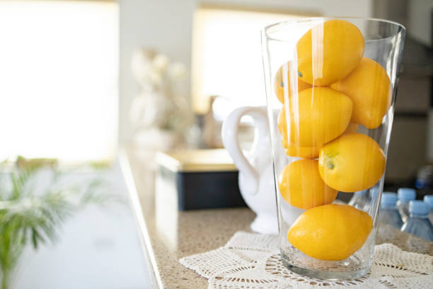 Kitchen, Decor, Stills Life - A glass vase full of lemons and jar stored on the kitchen counter