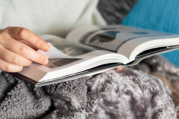 istock Woman with warm blanket reading a book 1225230004
