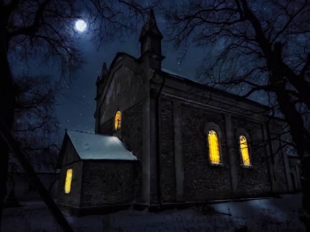 Old church at night with lights in the windows under the moonlight