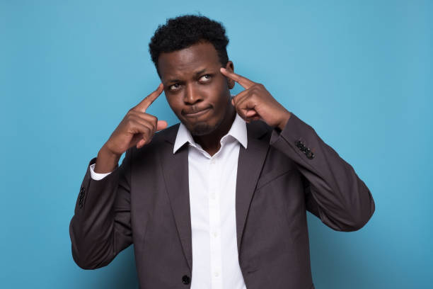 istock african american man in suit keeps fingers on temples, generating idea 1225231500
