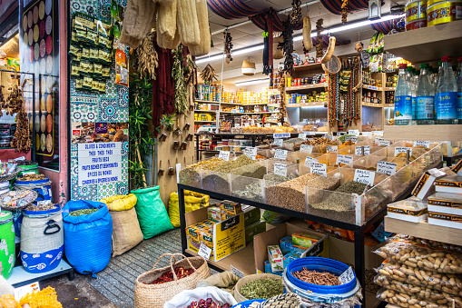 Many dried flowers, herbs, leaves and fruits on a sales counter at the spice market in Istanbul, Turkey, high angle view. Huge variety of traditional eastern sweets at the Grand Bazaar. Colourful herb background with copy space.