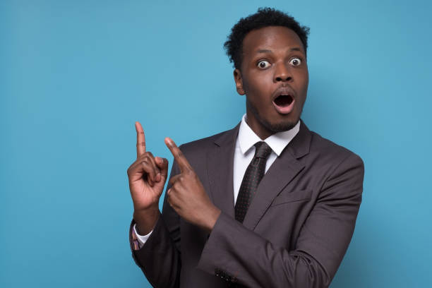 istock Shocked handsome young black business man pointing his hand up 1225231803