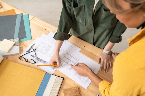 istock Two creative female designers bending over table while discussing sketches 1225234122