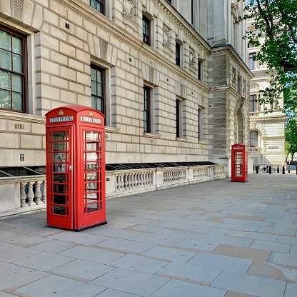 British red telephone boxes in an empty street in Westminster, London