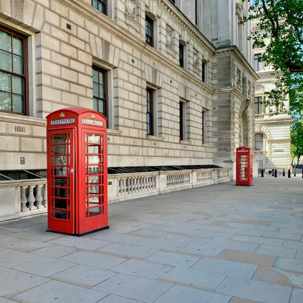 british red telephone boxes in an empty street in westminster, london - city of westminster big ben london england whitehall street imagens e fotografias de stock