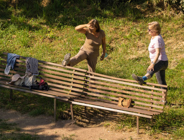 groupe de personnes âgées masquées et démasquées faisant de la gymnastique sur une pelouse à rome pendant l’auto-isolement - unmasked photos et images de collection