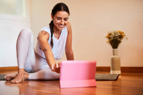una giovane istruttrice di yoga femminile insegna online. - yoga meeting foto e immagini stock