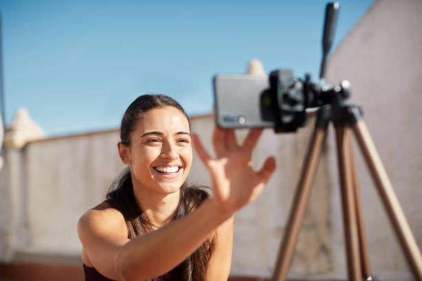 One young woman adjusting the camera before teaching online.