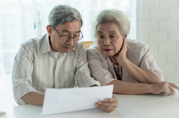 istock Asian senior couple holding document together at home 1225242878