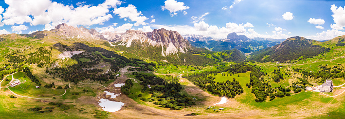 Aerial top view from drone to Col Raiser plateau in sunny summer Day. Scenery of rugged Sella Mountain with green valley on grassy hillside village St. Cristina di Val Gardena, Bolzano, Seceda Italy