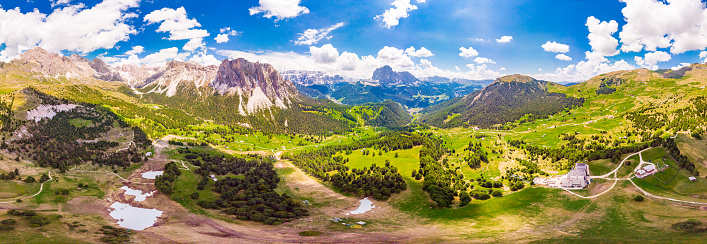 Aerial top view from drone to Col Raiser plateau in sunny summer Day. Scenery of rugged Sella Mountain with green valley on grassy hillside village St. Cristina di Val Gardena, Bolzano, Seceda Italy