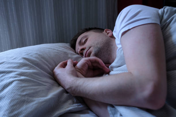 istock Young caucasian man sleeping in his bed 1225245561