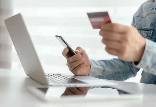 Close up of man hands entering credit card information using laptop keyboard for online shopping