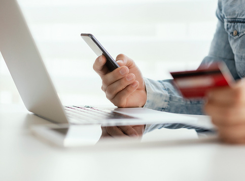 Close up of man hands entering credit card information using laptop keyboard for online shopping