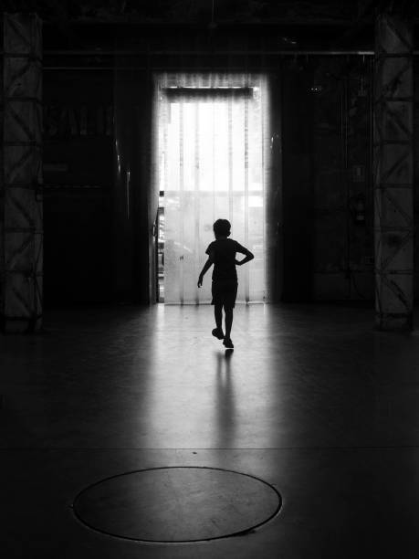 istock Boy silhouette crossing inside the door 1225254155