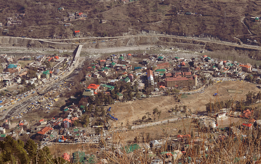 Overhead aerial view of the ancient city of Kullu, situated in the state of Himachal Pradesh in India; The Vyas River Flows through the Town, vintage matte style portrait, 5K