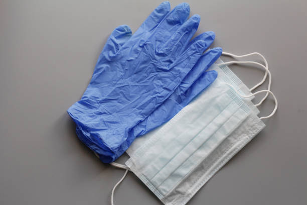 いくつかの使い捨ての医療フェイスマスクとラテックス手袋のペア。 - surgical glove surgical mask protective glove mask ストックフォトと画像