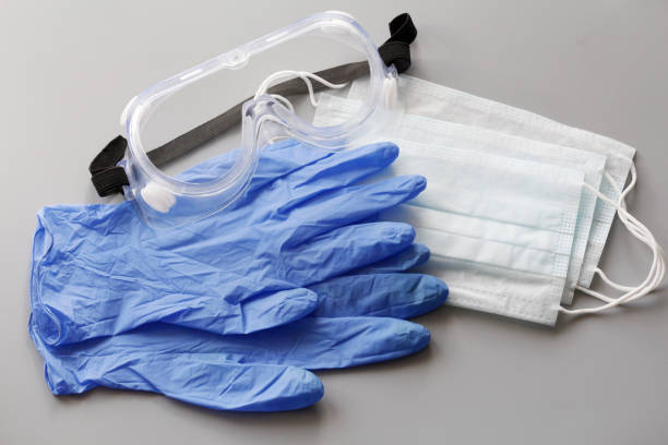 いくつかの使い捨ての医療フェイスマスクとラテックス手袋のペア。 - surgical glove surgical mask protective glove mask ストックフォトと画像