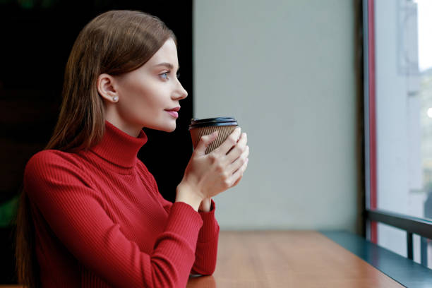 istock Young woman drinking coffee and day dreaming 1225256594