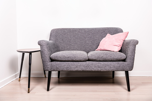gray settee with a pink pillow sitting