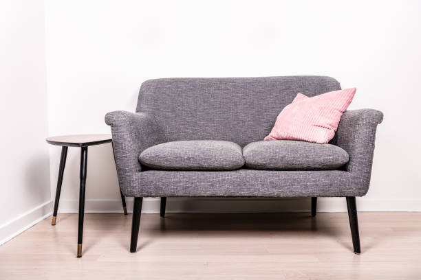 settee cinza com um travesseiro rosa sentado - sitting area - fotografias e filmes do acervo