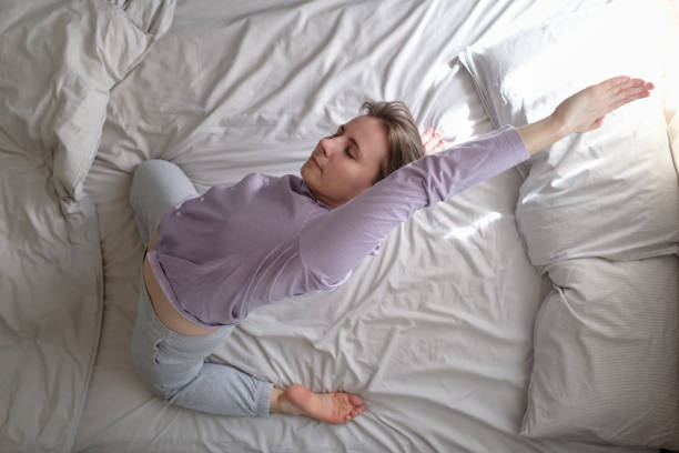 istock Young woman doing yoga exercise on bed at home. 1225260062