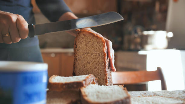istock Cooking breakfast. A young woman cuts bread 1225264994