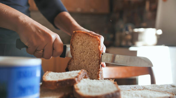 istock Cooking breakfast. A young woman cuts bread 1225265002